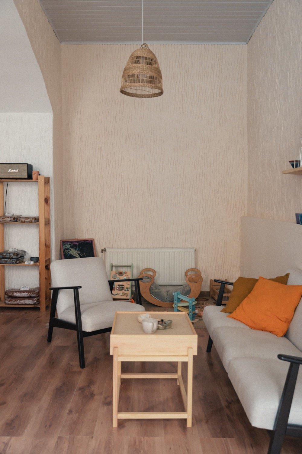 Studijos poilsio erdvė su sofa ir vaikų kampeliu